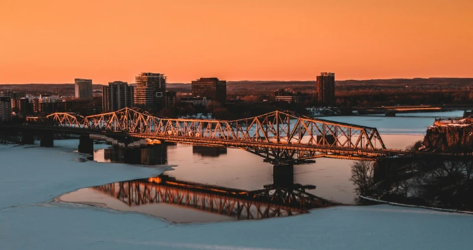 a bridge over a body of water with a city in the background